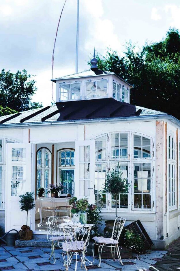 Diese quadratische Orangerie wird als weißes Gartenhaus genutzt und